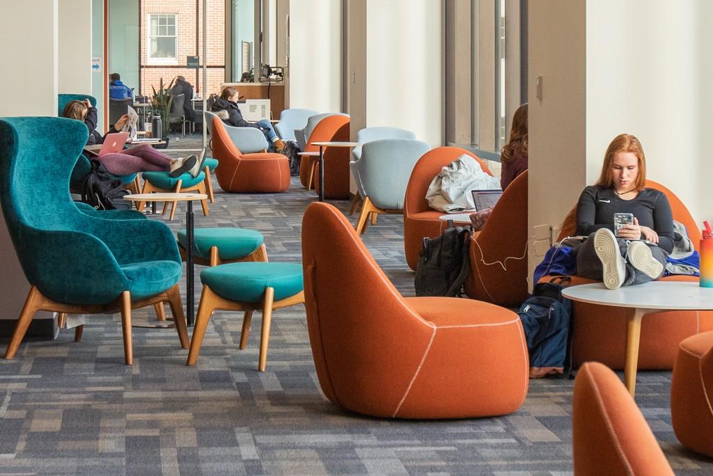  students relax in comfy chairs on the second floor of the Ripich共用